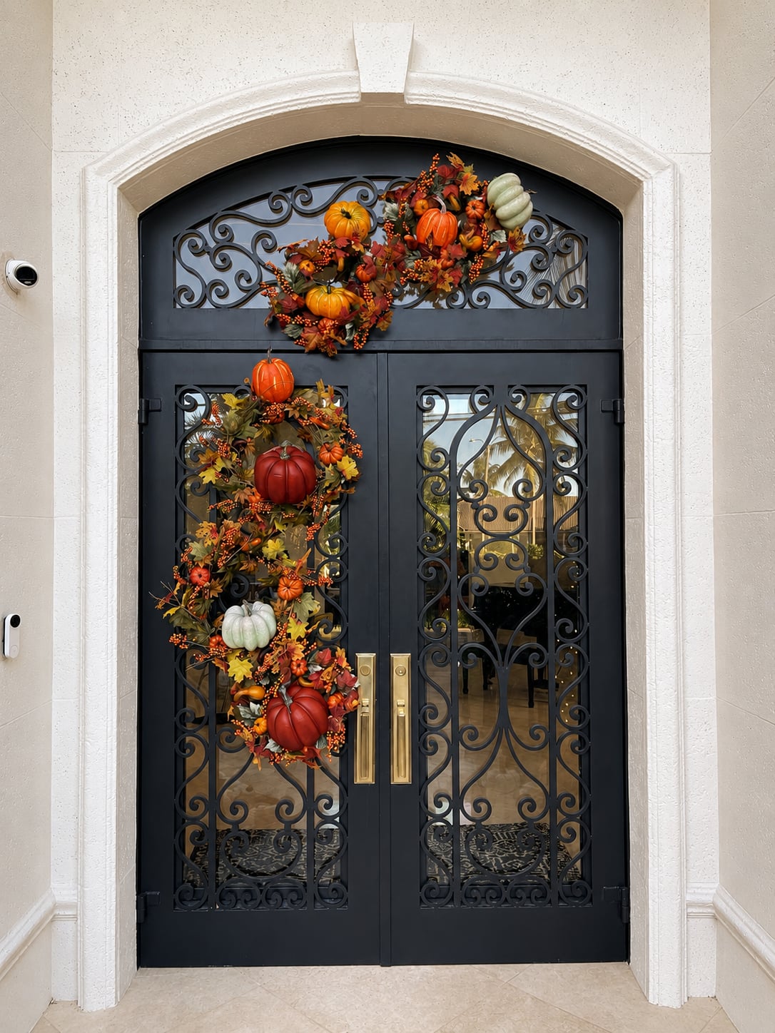 An autumn garland of pumpkins and leaves on an iron front door