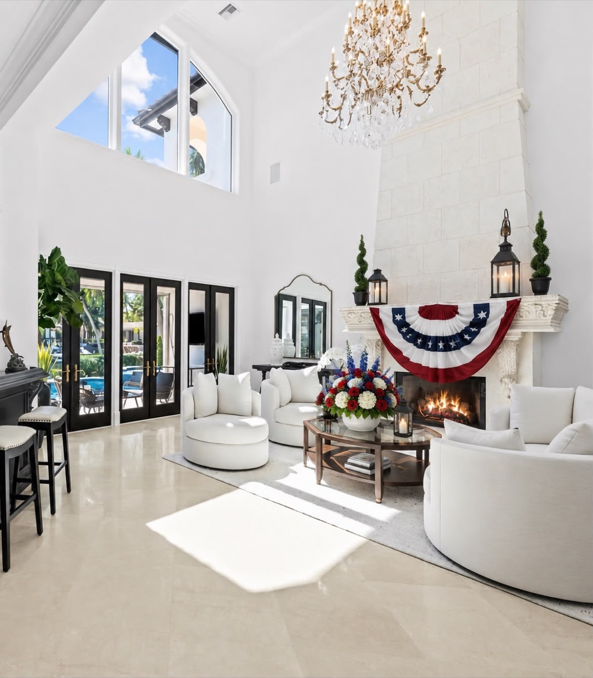 A white living room dressed for the Fourth of July — bunting over the fireplace